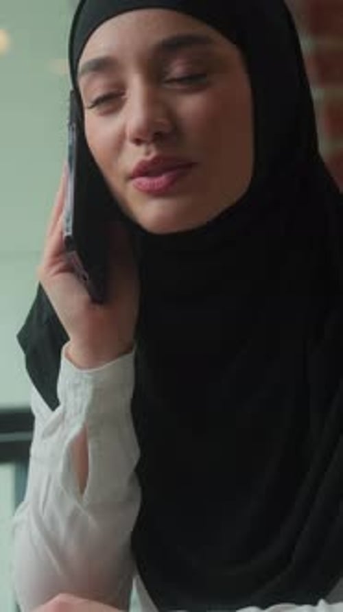 Happy Smiling Islamic Muslim Business Woman in Hijab Speaking with Mobile Phone in Office Workplace