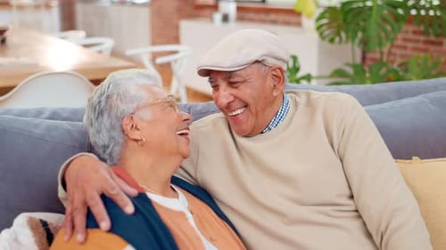 Loving Senior Couple Laughing Together on Sofa