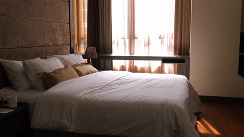 Bright Morning Sun on Cozy Bed in Modern Hotel Room with Luxurious