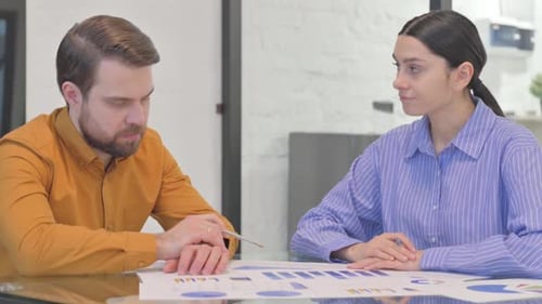 Business Colleagues Discussing Charts in Office