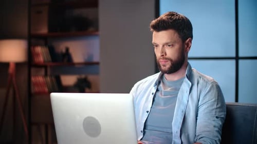 Man Working on Laptop in Home Interior at Night