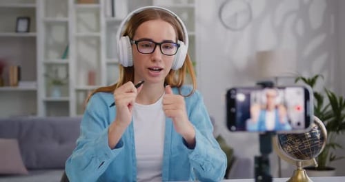 Vlog de grabación de una bloguera influyente atractiva con auriculares.