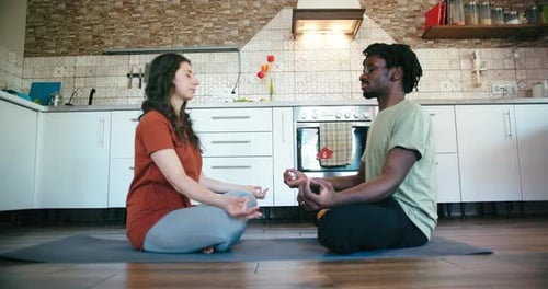 Couple Meditating in Lotus Position on Yoga Mat
