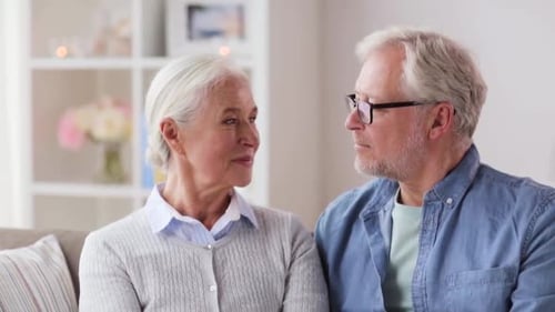 Smiling Senior Couple Embracing on Sofa at Home
