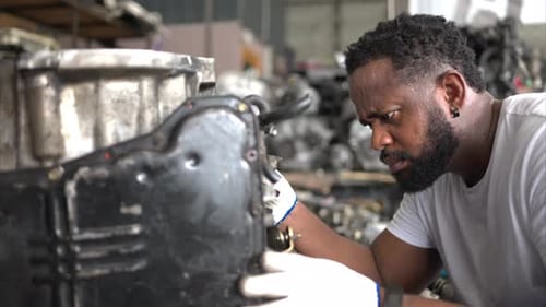 Hommes réparant un moteur de voiture dans un atelier de réparation automobile, focalisation sélective.