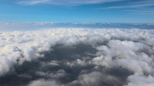 Aerial View From Airplane Window at High Altitude of Earth Covered with Puffy Cumulus Clouds Forming