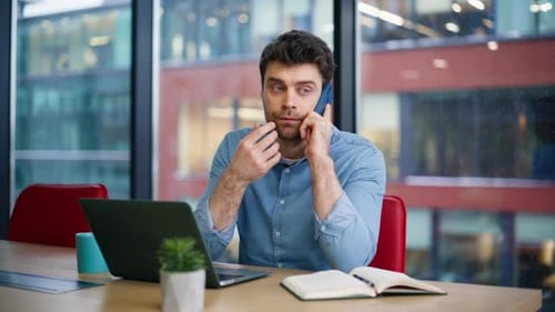 Office Professional Calling Mobile Phone Looking Laptop at Workplace Closeup