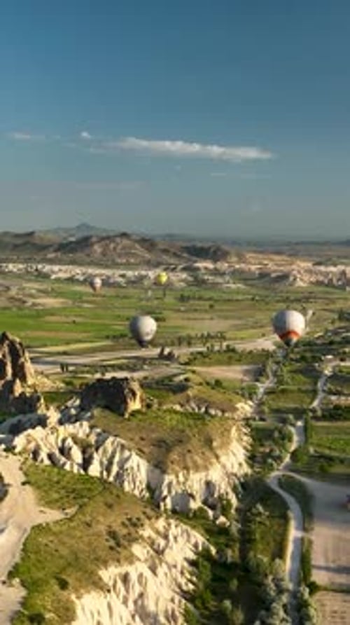Vertical Video Hot Air Balloons Fly Over the Mountainous Landscape of Cappadocia Turkey