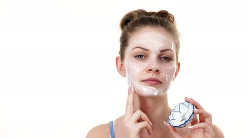 Woman Applies White Face Mask for Skincare