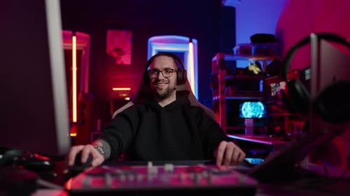 Adult Gamer Smiling in Tech-Filled Room