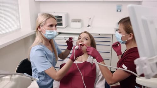 Dental professionals treat patient in bright modern clinic
