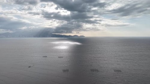 Drone aerial coastal view of ocean sunbeams and boat