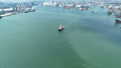 Aerial View of River Port with Ship Movement and City Backdrop