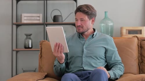 Man Using a Tablet While Sitting on Couch