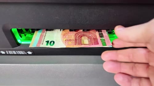 Close-up view then withdrawing euro banknotes from ATM after accepted, France.