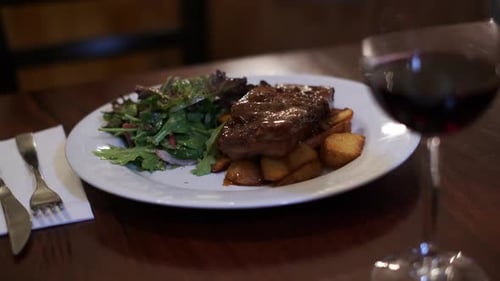 Caramelised roasted pork belly with roasted potato and salad on table ina restaurant