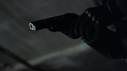 Gloved Hand Reloading a Pistol in Dark Room