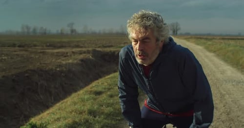 Middle Aged Man Running on Rural Dirt Road