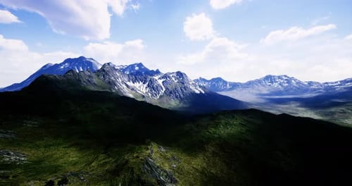Majestic Mountain Range Under a Bright Blue Sky and Scattered Clouds
