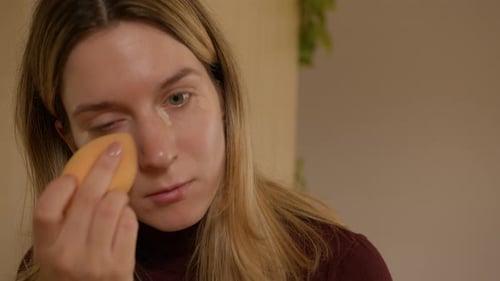 Woman Applying Makeup With Beauty Sponge Close Up
