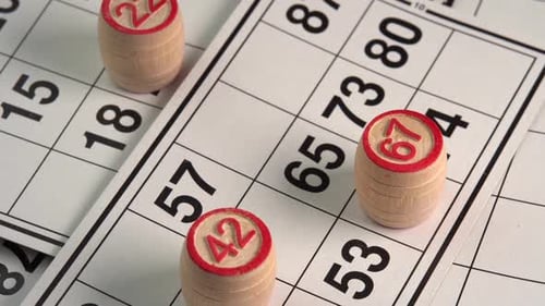 Lotto cards with numbers board game with wooden barrels close up rotate background. Bingo game
