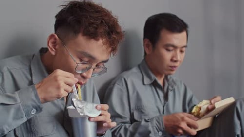 Construction Workers Eating Instant Noodles and Sandwich at Workplace