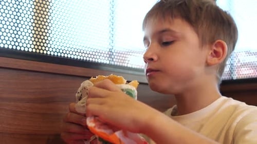 Boy Eating Burger at Restaurant