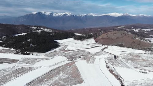 Drone snow covered mountain fields and peaks on a sunny winter day