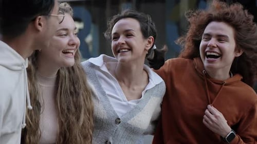 Group of Young Cheerful Gen Z Friends Hanging Out Outdoors After in the City in the Evening