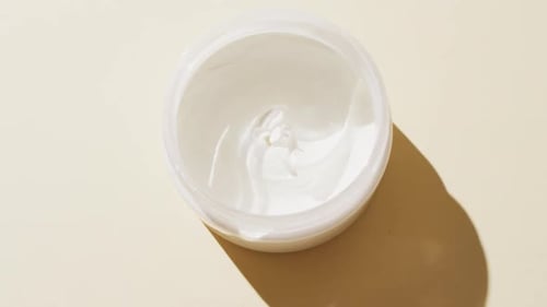 Close up of white cream on beige background with copy space