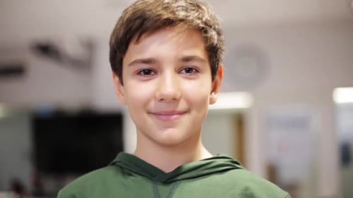 Smiling Boy in Green Hoodie Looking at Camera
