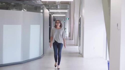 Businesswoman Walking in Office Corridor Businesswoman