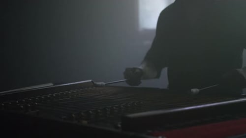 Close up of male hand playing traditional folk music on a dulcimer string instrument