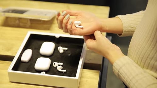 Une femme présente joyeusement des AirPods mettant en valeur le design et le confort