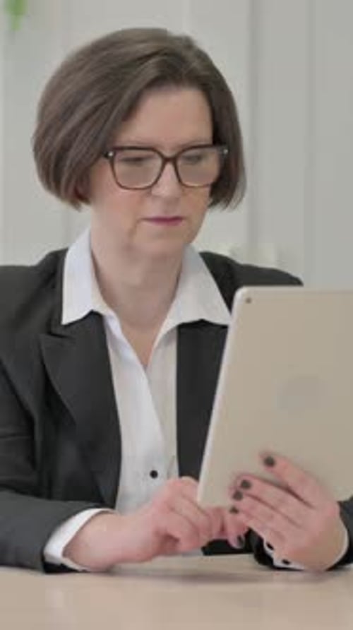 Woman in Suit Using Tablet for Video Call