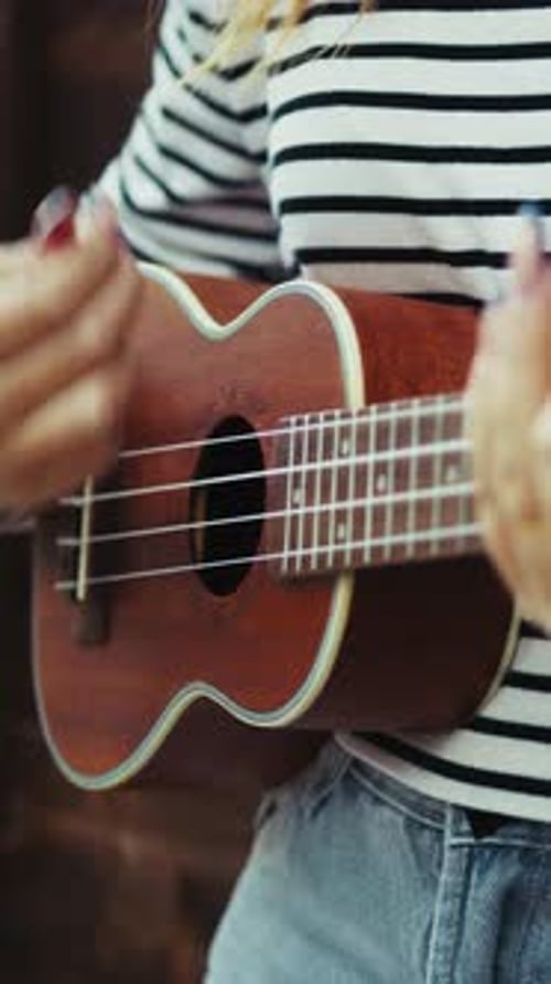 Young Adult Playing Ukulele Indoors