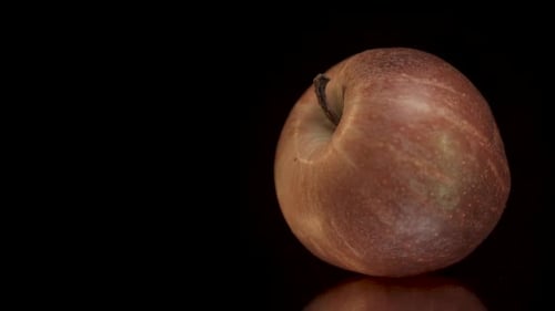 Apple in slow-motion tracks and spins across the frame from right to left, revealing close up detail