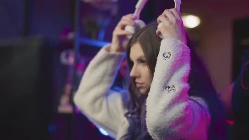 Rear View Gamer Placing Headphone on Desk in Neon Gaming Setup