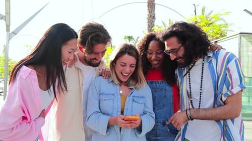 Friends Laugh Together at Phone in City