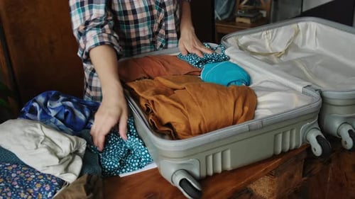 Woman is Packing Her Suitcase with Clothes