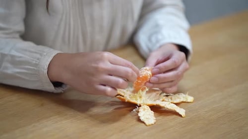 A woman who eats the white streaks of a mandarin orange
