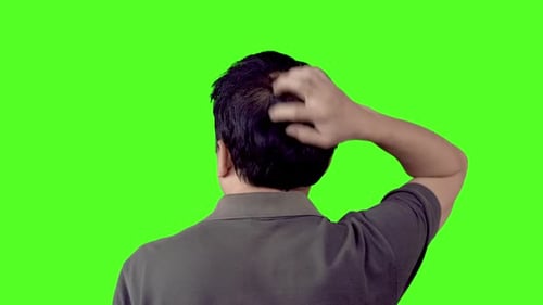 Man Scratching Head Against Green Background