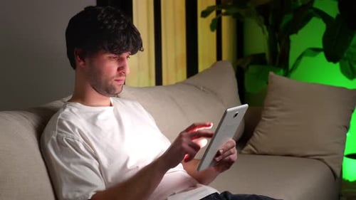 Man Relaxing at Home Using a Tablet
