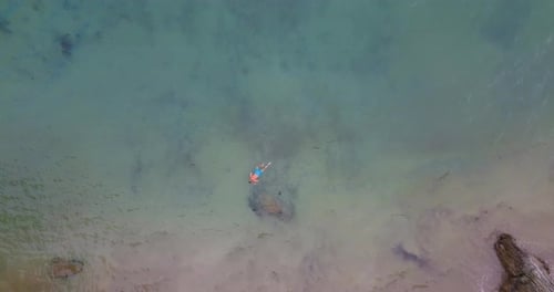 Vue aérienne d'un homme portant un maillot de bain bleu faisant de la plongée avec tuba sur la plage au large de Gali