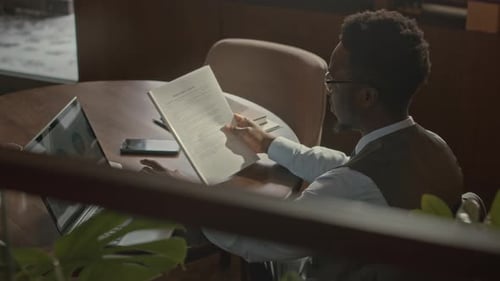 African American Businessman Working with Documents in Restaurant