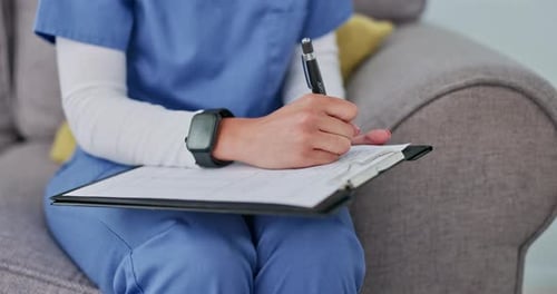 Medical Professional Writing on Clipboard in Home Setting