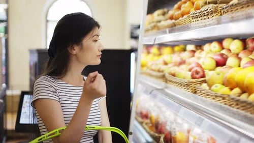 An Asian Shop Visitor Chooses Fruits