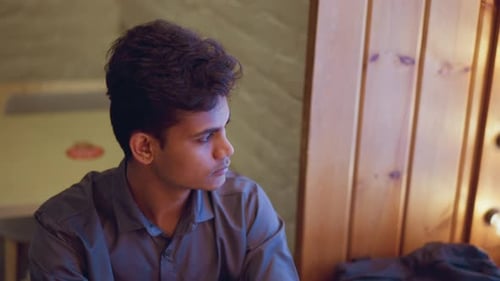 Thoughtful Young Man Looking off Camera in Interior