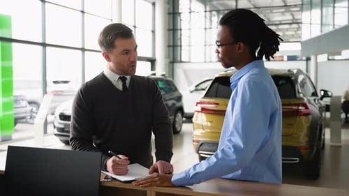 Car Salesman Assisting Customer at Dealership