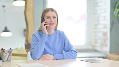 Young Adult Talking on a Smartphone Indoors